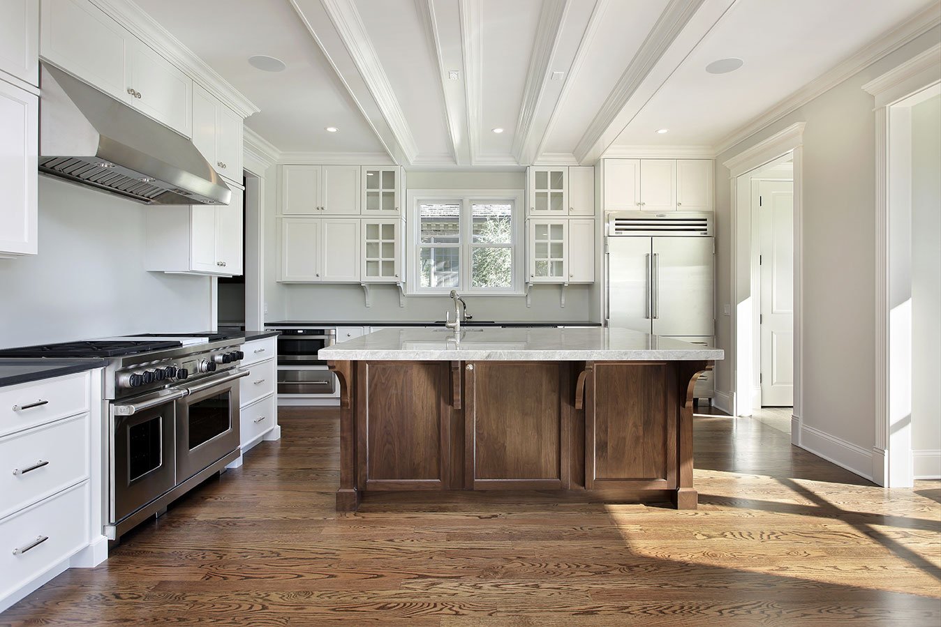 1. The kitchen features a large central island with a marble countertop, providing ample workspace. 