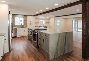 "Smooth, gray countertops with subtle veining create a sophi...