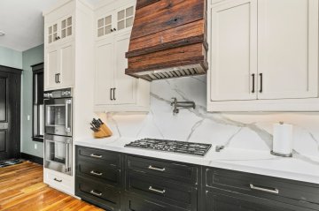 "Polished white countertops with elegant gray veining create...