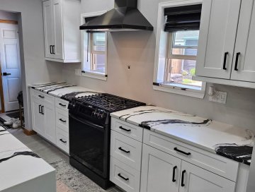 "The sleek white cabinets provide a clean and modern aesthet...