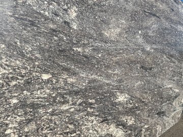 "The stunning quartzite countertops showcase a mesmerizing b...