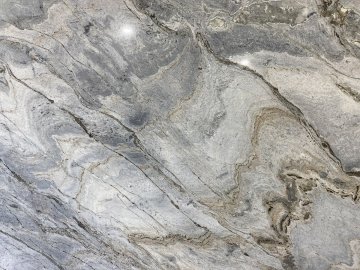 "The stunning quartzite countertops showcase a mesmerizing b...